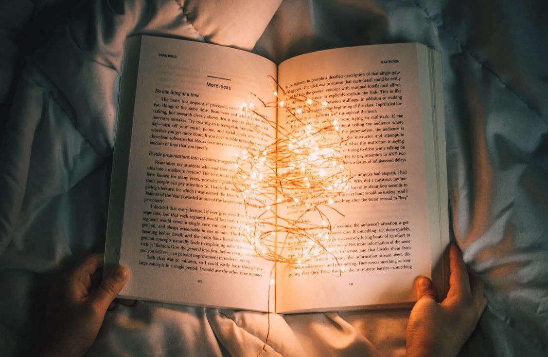 Soft teal and green shapes arranged like overlapping pages and threads, suggesting stories and reflections woven together.